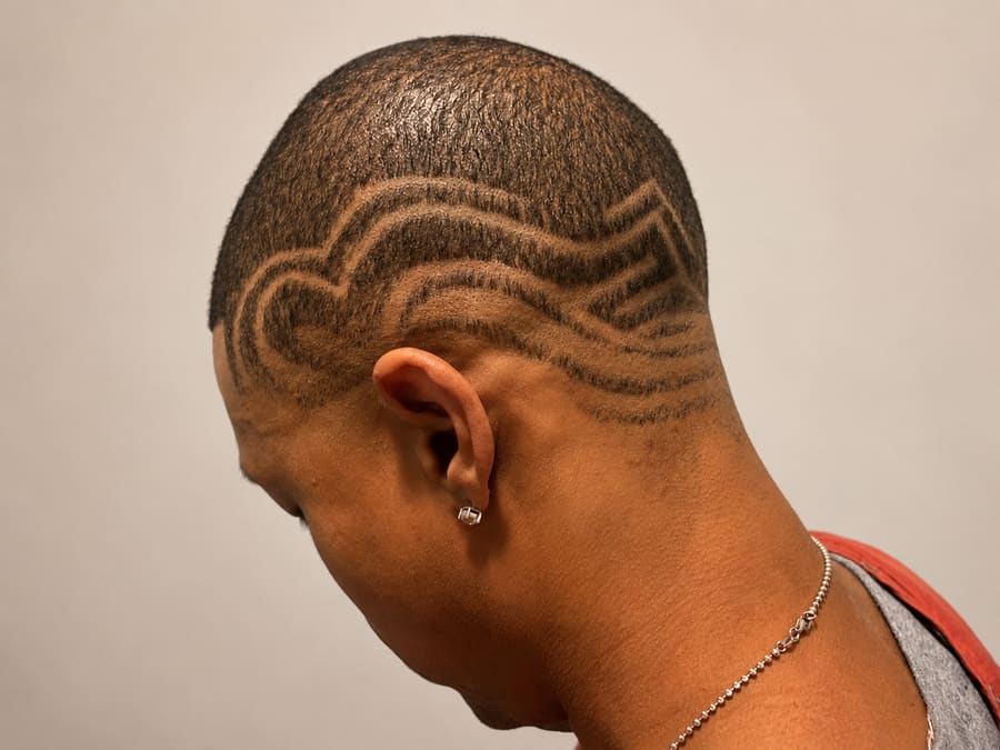 Back of a faded cut with a freehand curved-line design shaved into the side.