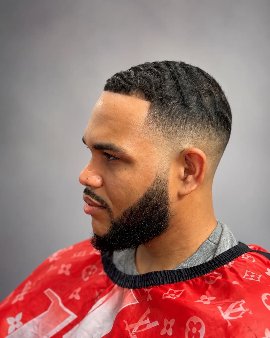 Brushed waves on top finished with a low taper fade and a full connected beard.
